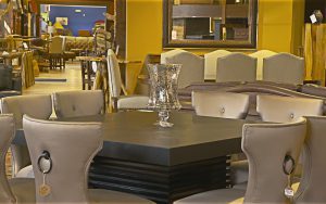 A table with chairs and a vase on top of it.