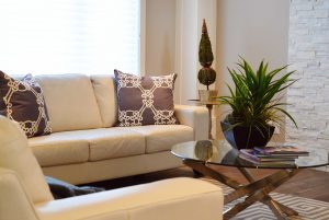 A living room with white furniture and plants