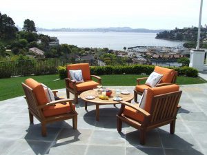 A patio with chairs and tables overlooking the water.